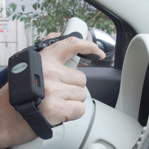 Accélérateur sans fil avec gâchette autour de la main d'un conducteur tenant son volant - conduite handicap