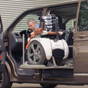 Plateforme élévatrice transférant un fauteuil roulant sur le rang 2 d'un véhicule pmr via sa porte latérale