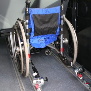 Système d'ancrage attaché à un fauteuil roulant de via le plancher à rail d'un minibus TPMR