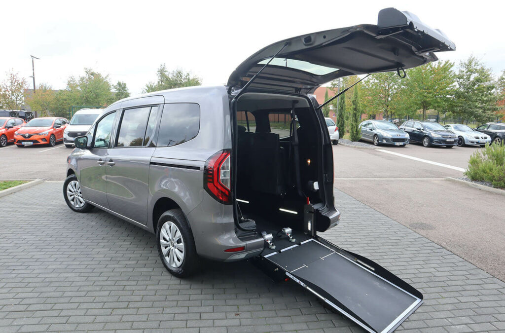 Vue arrière d'un Renault Grand Kangoo TPMR avec sa rampe déployée et son hayon ouvert - véhicule TPMR - transport handicap