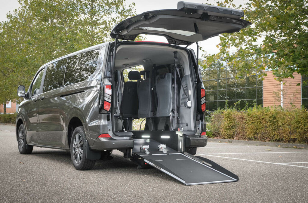 Ford Tourneo Custom TPMR vue de 3/4 arrière avec rampe et hayon arrière déployée - Véhicule TPMR - Transport handicap