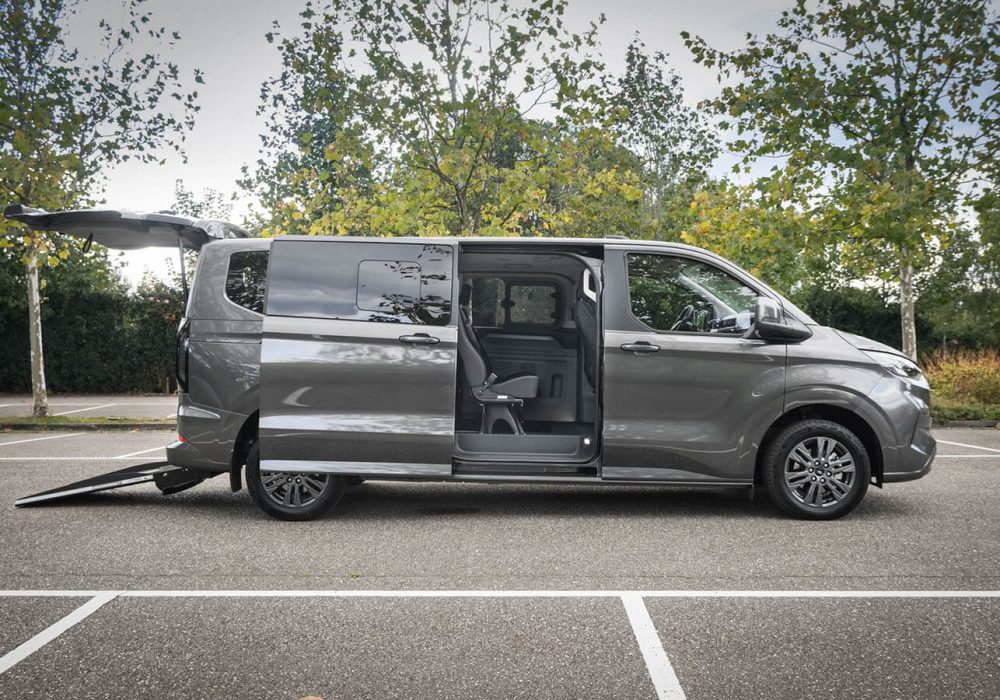 Ford Tourneo Custom TPMR avec sa porte coulissante latérale ouverte, son hayon et sa rampe déployée - Véhicule TPMR - Transport handicap