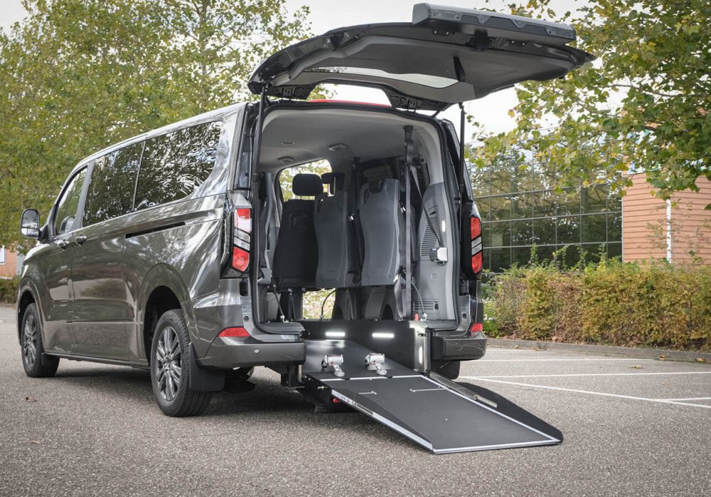 Ford Tourneo Custom TPMR vue de 3/4 arrière avec rampe et hayon arrière déployée - Véhicule TPMR - Transport handicap