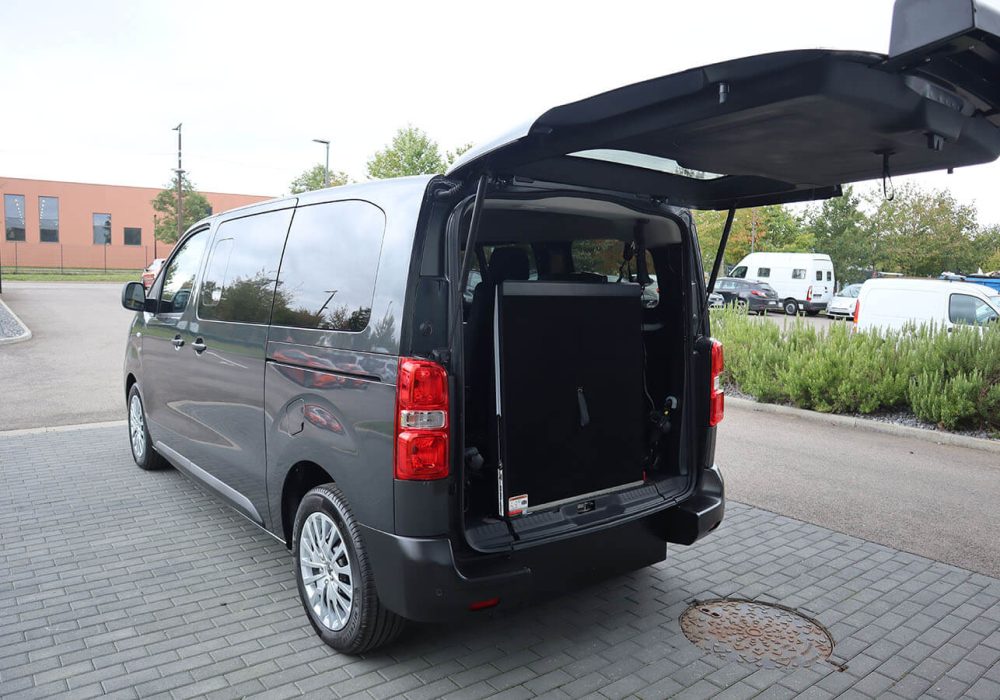 Vue de diagonale d'un Peugeot Expert Combi TPMR avec sa rampe à la verticale - véhicule TPMR - transport handicap